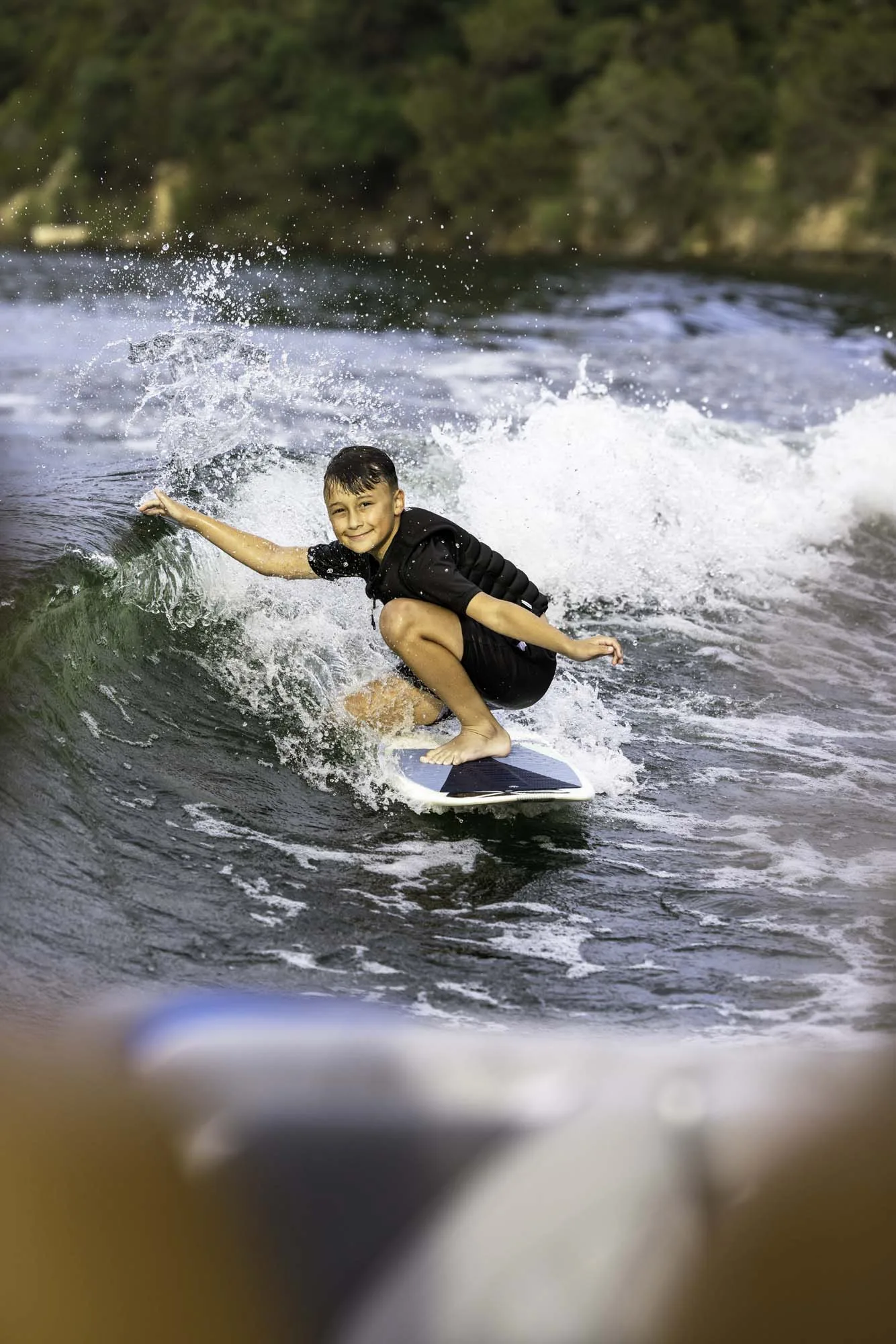 Young rider wake surfing with a smile